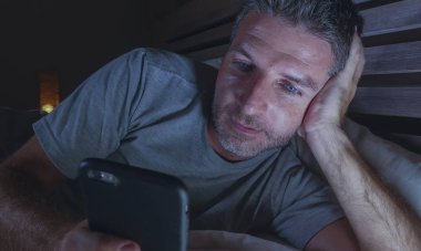 geç gece karanlık ışık cep telefonuyla internet bağımlılığı ve yaşam tarzı kavramı içinde sosyal medya online app zevk yatakta yatarken ağ ev yatak odası, genç çekici ve rahat adam