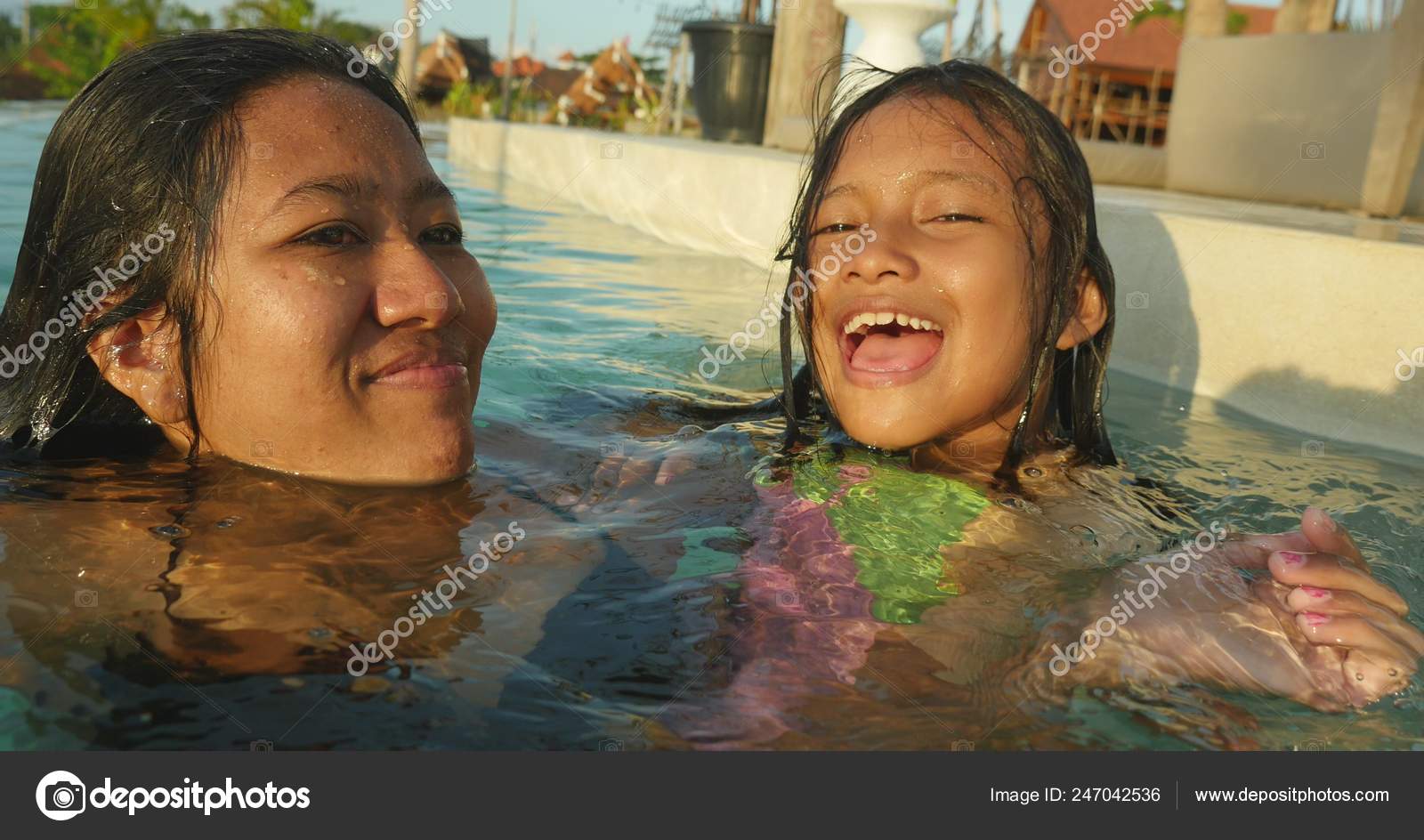 Lifestyle candid portrait of woman and young daughter 7 or 8 years old girl having fun togeth...