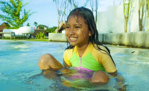 トロピカル リゾートで夏の休日を楽しんでいるスイミング プールで水と陽気な遊ぶ笑顔かわいい女の子水着で興奮して幸せの美しい子供のライフ スタイル肖像画 — ストック写真