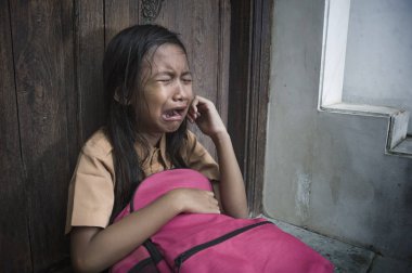 7 veya 8 yıl çocuk açık havada üzgün ve depresyonda ona zorbalık acı sırt çantası ve duygu bağımlılığı sorunu yalnız ve çaresiz tutarak ağlamaya katta oturan okul üniformalı