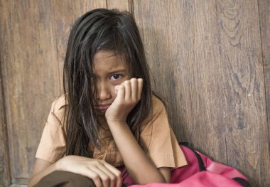 7 veya 8 yıl çocuk açık havada üzgün ve depresyonda ona zorbalık acı sırt çantası ve çaresiz hissediyor bağımlılığı sorunu tutarak ağlamaya katta oturan okul üniformalı