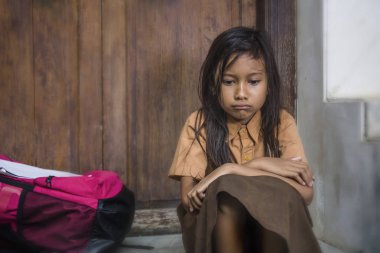 7 veya 8 yıl çocuk okul üniforması oturma açık havada üzgün ve depresyonda çantasını zorbalık acı merdiven ve yalnız ve çaresiz hissediyor bağımlılığı sorunu ile