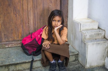7 veya 8 yıl çocuk okul üniforması oturma açık havada üzgün ve depresyonda çantasını zorbalık acı merdiven ve yalnız ve çaresiz hissediyor bağımlılığı sorunu ile