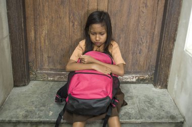 7 veya 8 yıl çocuk okul üniforması oturma açık havada üzgün ve depresyonda çantasını zorbalık acı merdiven ve yalnız ve çaresiz hissediyor bağımlılığı sorunu ile