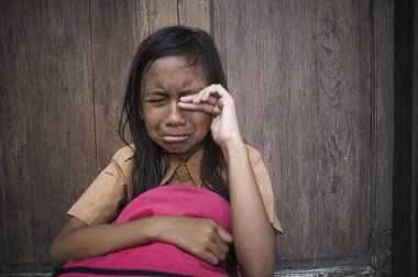7 veya 8 yıl çocuk açık havada üzgün ve depresyonda ona zorbalık acı sırt çantası ve duygu bağımlılığı sorunu yalnız ve çaresiz tutarak ağlamaya katta oturan okul üniformalı