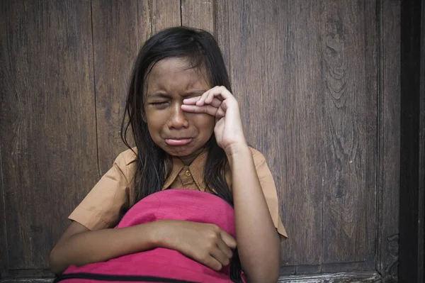 7 veya 8 yıl çocuk açık havada üzgün ve depresyonda ona zorbalık acı sırt çantası ve duygu bağımlılığı sorunu yalnız ve çaresiz tutarak ağlamaya katta oturan okul üniformalı