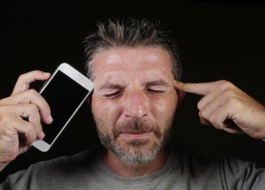 sosyal medya app yüzüne karşı cep telefonu tutarak ve siyah arka plan üzerine izole bağımlılığı dating online genç çekici ve yakışıklı internet bağımlısı adam