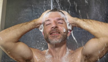 doğal yüz portre genç çekici ve mutlu adam evde veya spor salonu banyo rahat ve neşeli saçları şampuanla yıkama sabah duş keyfini