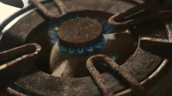 Крупным планом сжигание старого ржавого кухонного кольца после включения в огонь с более легким пламенем в опасной газовой энергии и концепции домашней кухни — стоковое фото