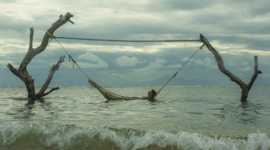 ağaç gövdeleri tropik ada plaj rahatlatıcı tatil seyahat kaçış ve Turizm hedef, rahat ve mutlu şaşırtıcı deniz hamakta yatan adam set up