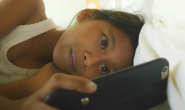 Estilo de vida retrato de dulce feliz y hermoso niño de 7 años de edad que se divierten jugando juego de Internet con el teléfono móvil acostado en la cama alegre y emocionado — Foto de Stock