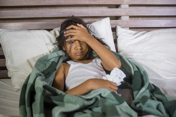 Életmód otthon portré fiatal szép és édes 8 éves női gyermek gazdaság selyempapír tüsszögés orrát ágyon beteg influenza vagy hideg vírus — Stock Fotó