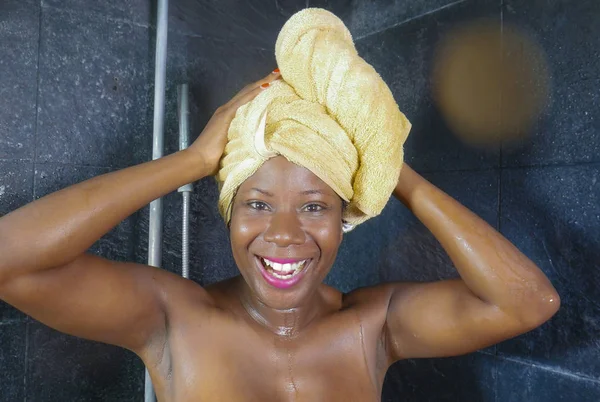 Lifestyle πορτρέτο του όμορφη μαύρη Αφρο Αμερικανική γυναίκα έχοντας ένα ντους με το κεφάλι τυλιγμένο σε μια πετσέτα χαμογελώντας χαρούμενα στην έννοια υγιεινή και ομορφιά — Φωτογραφία Αρχείου