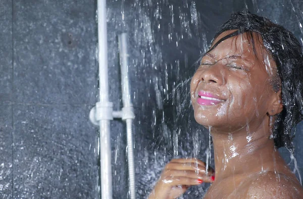 Domowych portret szczęśliwy młody i piękny czarny African American kobieta uśmiecha się zadowolony branie prysznica w domowej łazience mycia włosy szamponem — Zdjęcie stockowe