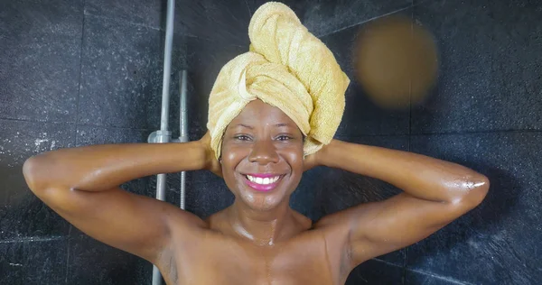 Retrato de estilo de vida de jovem bela negra afro-americana tendo um chuveiro com a cabeça envolta em uma toalha sorridente alegre em higiene e beleza — Fotografia de Stock
