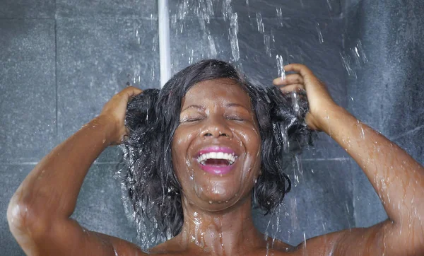 Portrait de style de vie domestique de jeune femme afro-américaine heureuse et belle souriante heureuse prenant une douche à la maison salle de bain laver ses cheveux avec un shampooing — Photo