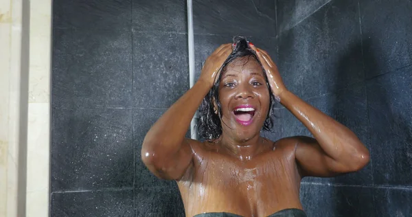 若い幸せの国内のライフ スタイル肖像画、幸せな笑みを浮かべて美しい黒アフロ ・ アメリカ人女性はシャンプーで髪を洗って家のバスルームでシャワーを浴びてください。 — ストック写真