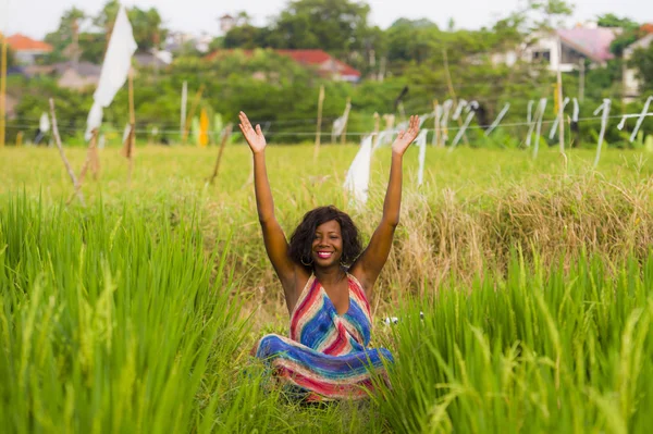 Young beautiful and happy black afro American woman sitting at rive field outdoors practicing yoga relaxation and meditation enjoying holidays — Stock Photo, Image