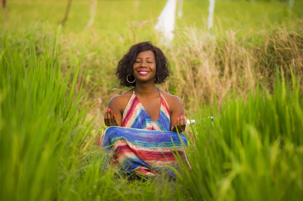 Fiatal szép és boldog fekete afro-amerikai nő ül rive mező szabadban gyakorló jóga-relaxáció és meditáció élvezi a nyaralás — Stock Fotó