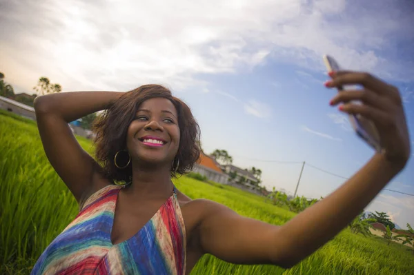 Ευτυχής και ελκυστικό μαύρο afro Αμερικανός γυναίκα σε όμορφο φόρεμα λαμβάνοντας αυτοπορτρέτα πορτρέτο με internet κινητής τηλεφωνίας απολαμβάνοντας διακοπές ταξίδια στην Ασία χαμογελώντας χαρούμενα στο τομέα του ρυζιού — Φωτογραφία Αρχείου