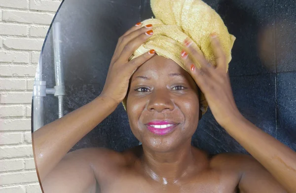 Domowych portret lustro odbicie młode piękne czarne afro American kobiety mokre po prysznicem z jej głową owinięty w ręcznik uśmiechający się wesoły — Zdjęcie stockowe