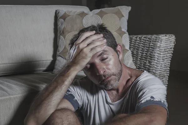 Mode de vie portrait jeune homme attrayant triste et déprimé assis sur le sol du salon se sentant désespéré et stressé souffrant dépression et problème d'anxiété à la recherche frustré — Photo