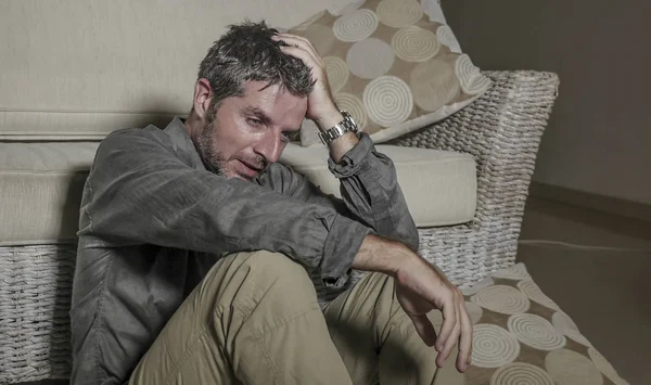 Retrato do estilo de vida jovem atraente triste e deprimido homem sentado na sala de estar chão sentimento desesperado e estressado sofrimento depressão e ansiedade problema olhar frustrado — Fotografia de Stock