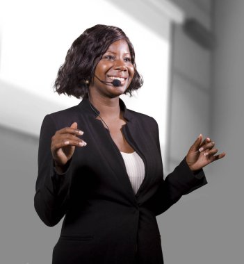 genç çekici ve kendinden emin siyah Afrika kökenli Amerikalı iş kadın kurumsal eğitim etkinlik veya seminer motivasyon konferans veren Auditorium'da konuşan kulaklık ile