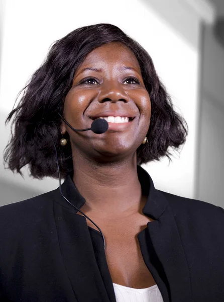 Jonge aantrekkelijke en vertrouwen zwarte Afrikaanse Amerikaanse zakenvrouw met headset spreken in auditorium op bedrijfsopleidingen evenement of seminarie geven motivatie conferentie — Stockfoto