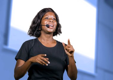 kurumsal eğitim etkinlik veya seminer veren motivasyon ve başarı koçluk Auditorium'da konuşan kulaklık ile başarılı siyah afro Amerikan girişimci kadın