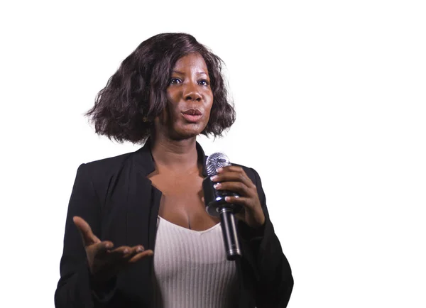企業のイベントやセミナーの分離指導の動機付けのスピーチを与えることで講堂で話すマイクを使って美しい黒アフロ アメリカン ビジネス女性 — ストック写真