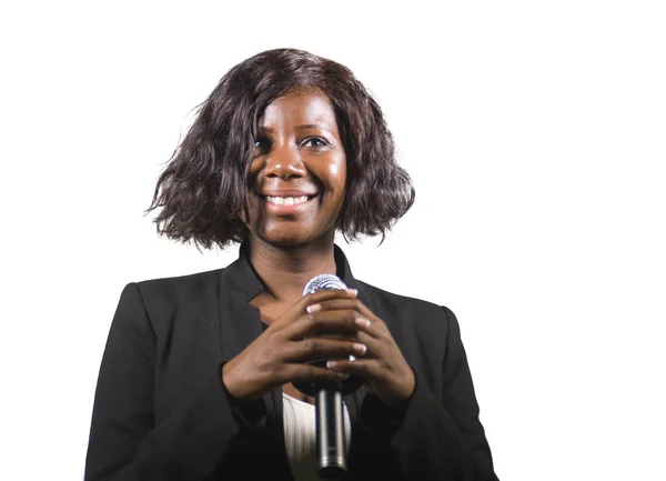 Красивая черная афро-американская деловая женщина с микрофоном, выступающая в аудитории на корпоративном мероприятии или семинаре, давая мотивационную речь тренера изолированы — стоковое фото