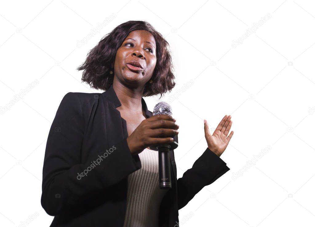  confident black African American business woman with microphone speaking in auditorium at corporate event or seminar giving motivational coaching speech isolated