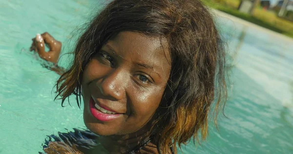 Glad och vacker svart afroamerikanska kvinna i bikini att ha kul på tropical beach resort pool avslappnad och lekfull leende glada njuter av lyx semester — Stockfoto