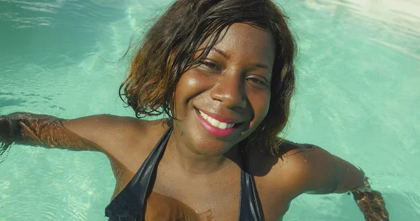 Szczęśliwe i piękne czarne African American kobieta w bikini, zabawy w tropikalnej plaży ośrodek basen spokojny i zabawny, uśmiechający się wesoły korzystających luksusowe wakacje — Zdjęcie stockowe