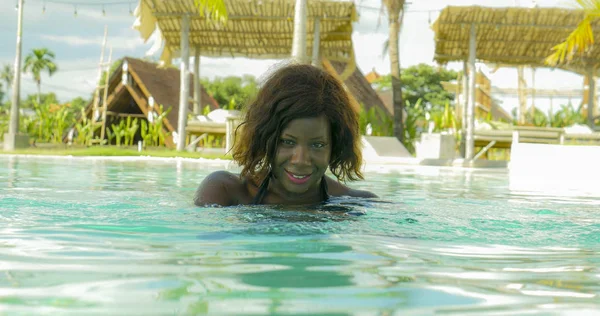 Feliz e bonita mulher negra afro-americana de biquíni se divertindo na praia tropical resort piscina relaxado e brincalhão sorridente alegre desfrutando de férias de luxo — Fotografia de Stock