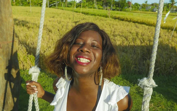 Fiatal, boldog és szép fekete-afrikai-amerikai nő nyári ruha játék a szabadban, a swing mosolygó, vidám és nyugodt birtoklás móka, lengő, trópusi üdülés — Stock Fotó
