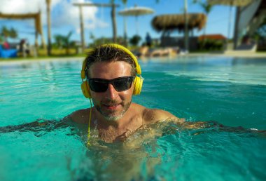 30'lu serin ve rahat dostum indulged duygu ve taze having fun yaz tatilleri kulaklık ile müzik tropikal lüks resort yüzme havuzunda oynak zevk