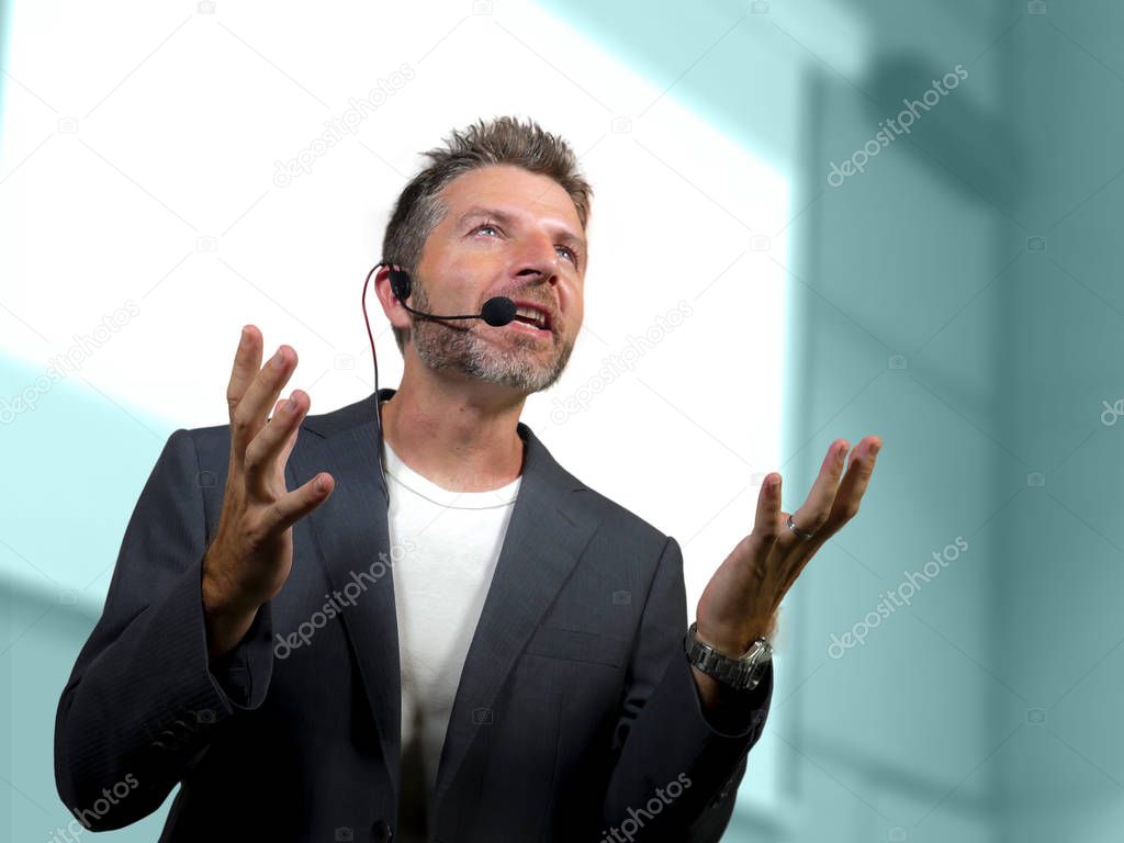 confident successful man with headset speaking at corporate business coaching and training auditorium conference room talking giving motivation training from speaker stage