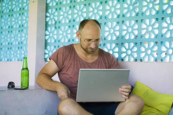 Junger glücklicher und selbstbewusster Backpacker, der mit Laptop im Freien arbeitet, entspannt als selbstständiger Unternehmer und digitaler Nomade im Internet-Businesskonzept — Stockfoto