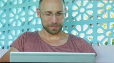 dizüstü bilgisayar ile çalışan ve ağ serbest girişimci ve dijital göçebe hipster mutlu ve kendine güvenen genç backpacker adam online iş başarı kavramı içinde memnun 