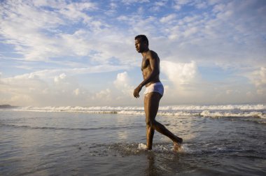 genç çekici ve seksi siyah Afro Amerikan adam ile seksi kaslı vücut yürüyüş güzel tropikal çöl plaj zevk yaz tatilleri ücretsiz ve rahat