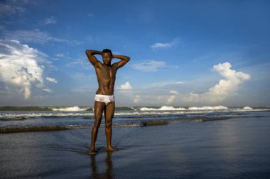 genç çekici ve uygun siyah Afro Amerikan adam portre yaz mavi gökyüzü izole sahilde serin model tutum poz güçlü kaslı vücut