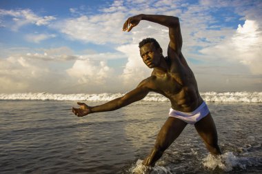 genç çekici ve uygun siyah Afro Amerikan adam portre yaz mavi gökyüzü izole sahilde serin model tutum poz güçlü kaslı vücut