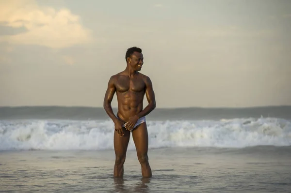 Retrato de playa de joven en forma y atractivo hombre afroamericano negro con musculoso hermoso cuerpo disfrutando juguetón en el mar jugando en el agua divirtiéndose — Foto de Stock