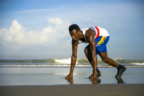 Junger athletischer und attraktiver schwarzafrikanisch-amerikanischer Läufer beim Lauftraining am Wüstenstrand in Fitness und Wellness isoliert am blauen Himmel — Stockfoto