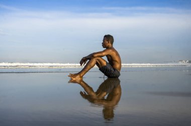 genç çekici ve rahat siyah Afro Amerikan adam uygun vücut ve kas arka sahilde oturan güzel görünüm düşünme ve meditasyon ücretsiz zevk