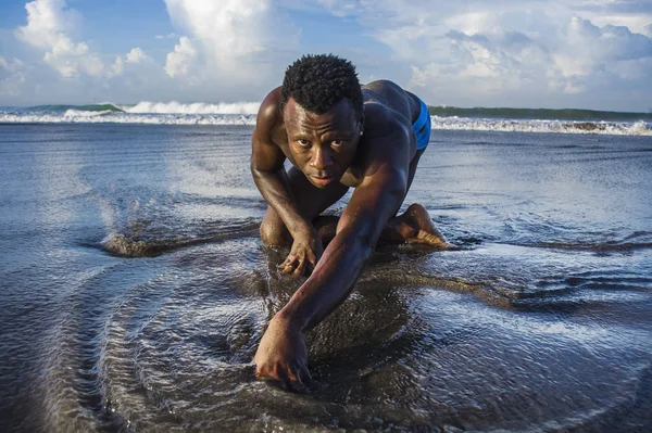 Joven atractivo y sexy negro afro americano hombre con atlético muscular cuerpo posando fresco en agua de mar en desierto playa en masculino belleza y plasticidad concepto — Foto de Stock