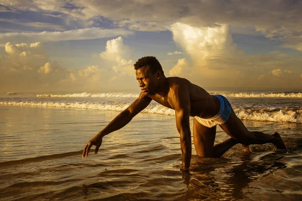 Young attractive and sexy black afro American man with athletic muscular body posing cool in sea water on desert beach in male beauty and plasticity concept — Stock Photo, Image