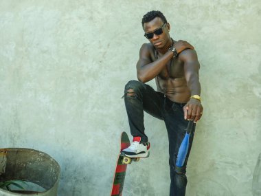 genç çekici ve yakışıklı siyah Afrika Amerikan adam uygun kaslı vücut ve altı paketi tutan beyzbol yarasa ve paten kurulu poz serin kentsel badass